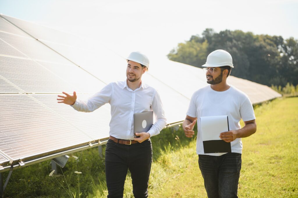 Two engineers or businessmen on the background of solar panels. Renewable energy. Green energy