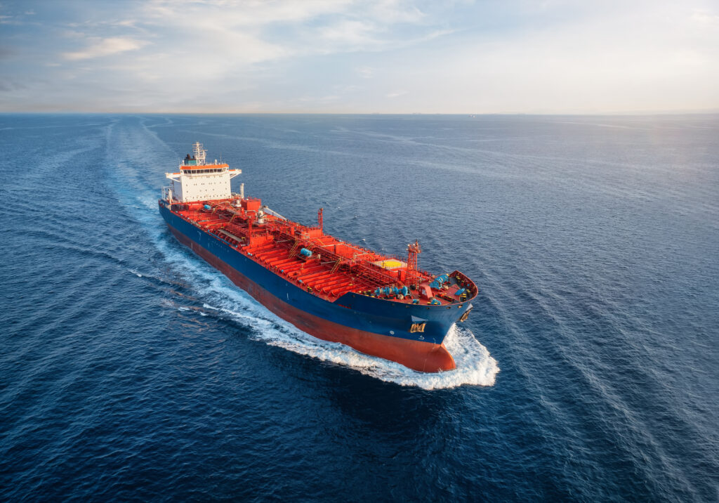 Aerial view of a chemical goods or crude oil tanker cargo ship traveling with full speed over the ocean