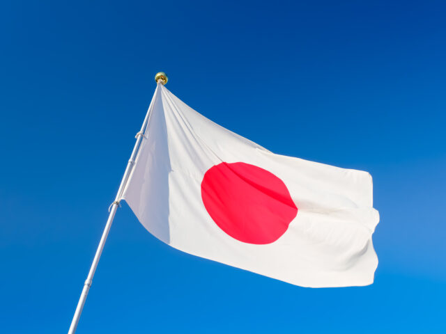 Japanese flag on blue sky.