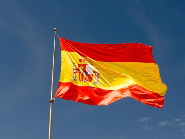 Image of the spanish flag against a dark blue sky so that the reader knows which country is mentioned in the text below.